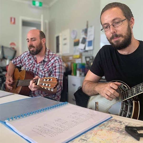 Studio23 program facilitators Craig (playing guitar) and Mitch (playing banjo).