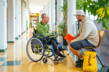 A young man in a wheelchair with his support worker at university