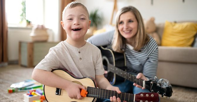 A young boy and his mum playing guitars