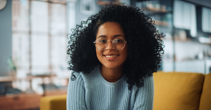 Young woman with dark curly hair, smiling