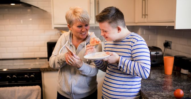 Mum and son eating toast in the kitchen, smiling