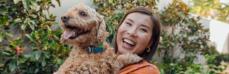 Happy woman holding a fluffy dog