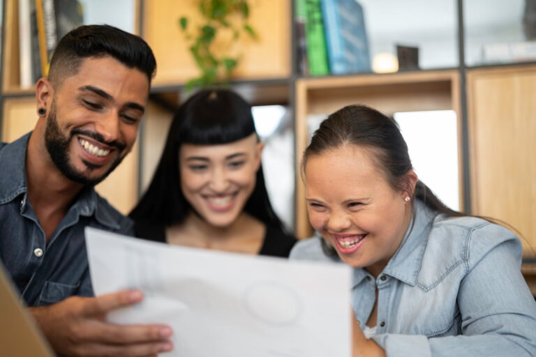 A young woman laughing with two work colleagues