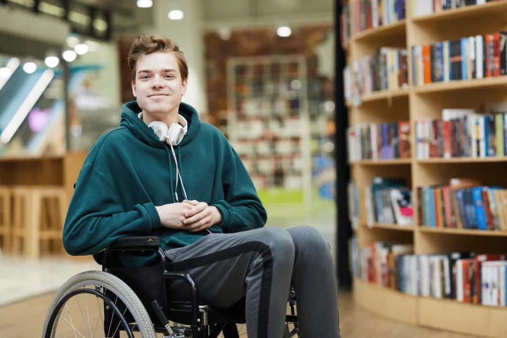 A young man in a wheelchair in the library