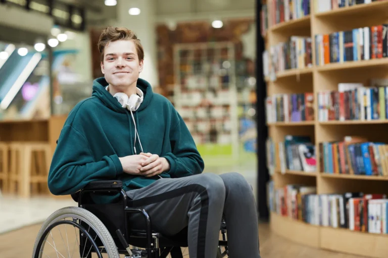 A young man in a wheelchair in the library