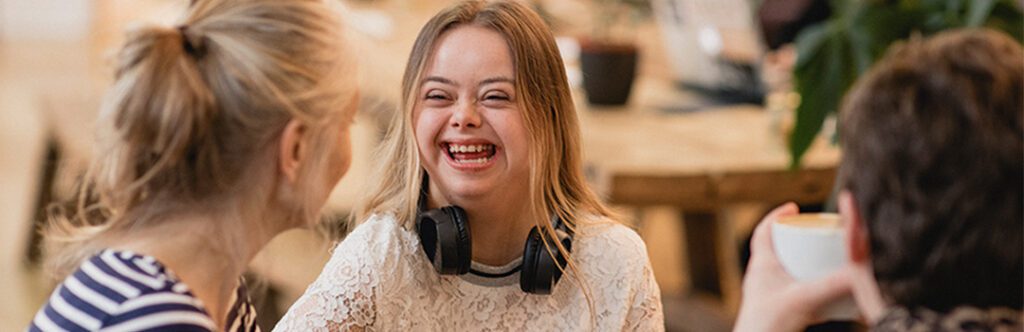 A young woman in a cafe with two friends