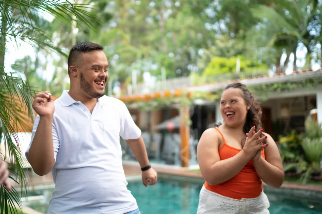 Two young adults dancing by the pool
