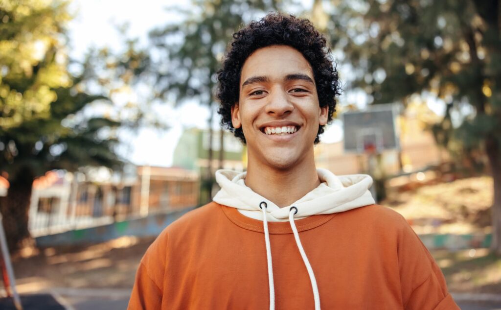 young person smiling outside