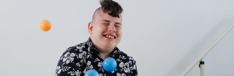 A young person playing with coloured balls