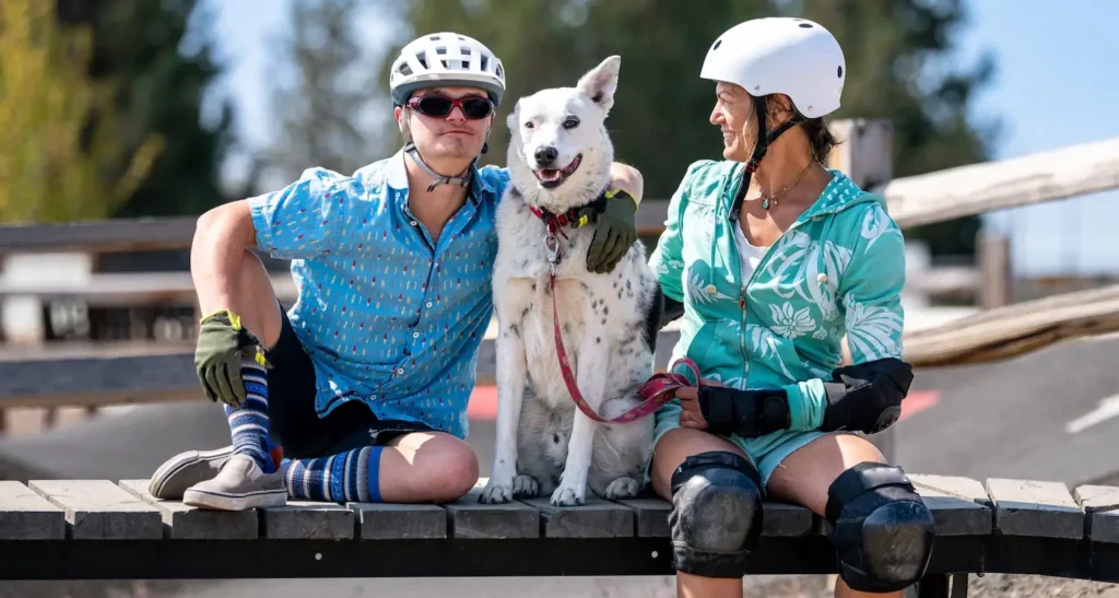 Mum and adult son sitting outside with their dog