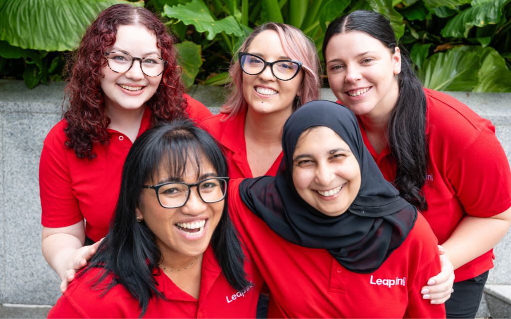 Five Leap in! employees smiling at the camera