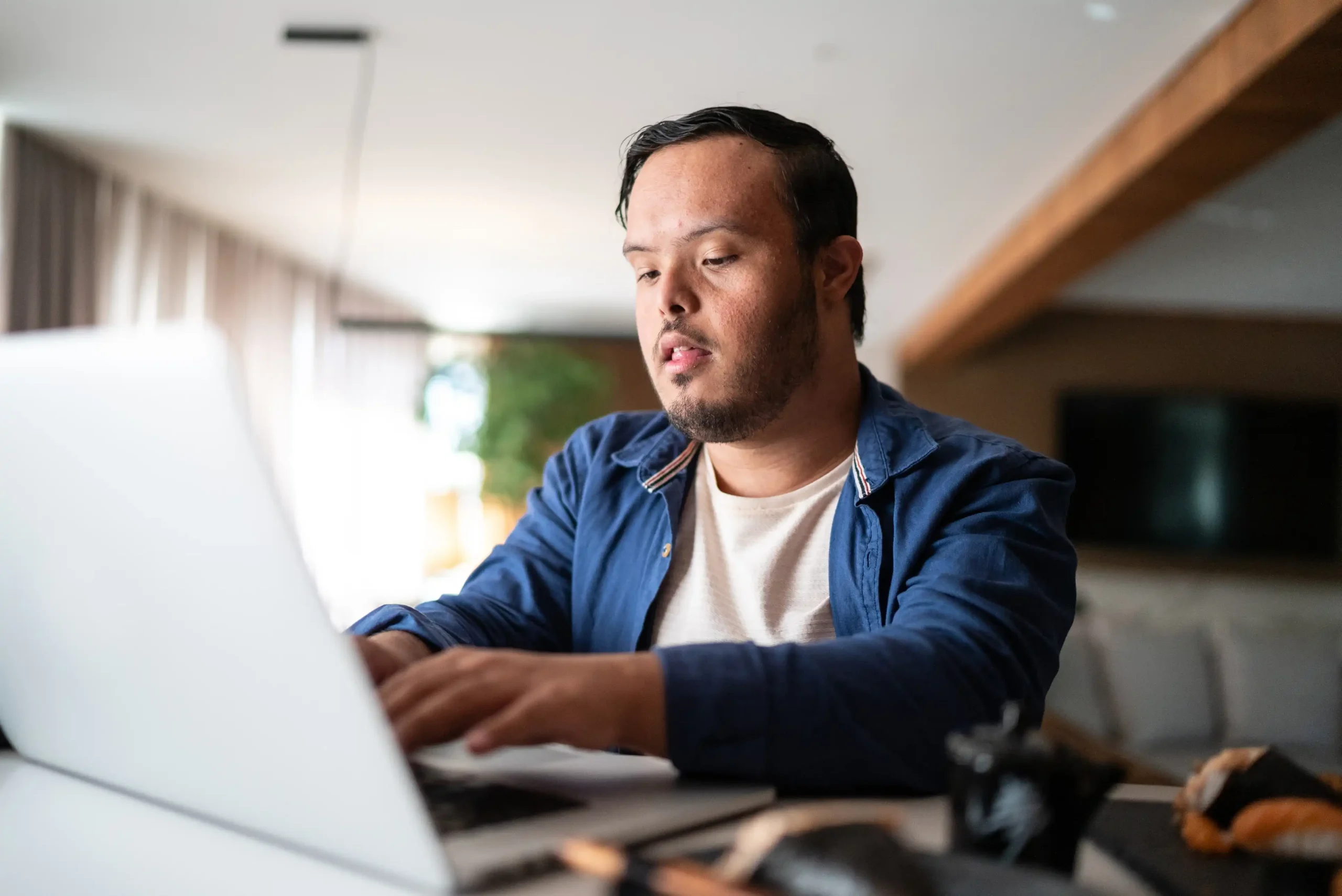 Young male looking at laptop at home.