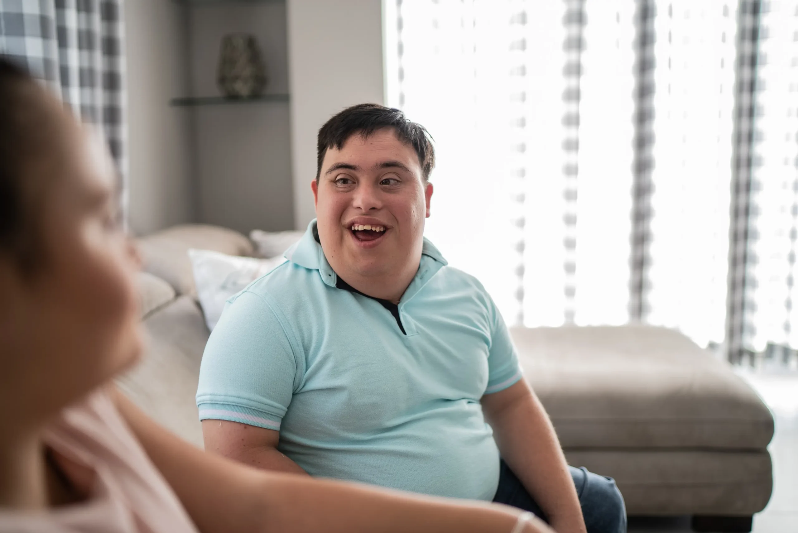 Young man sitting on couch talking to friend
