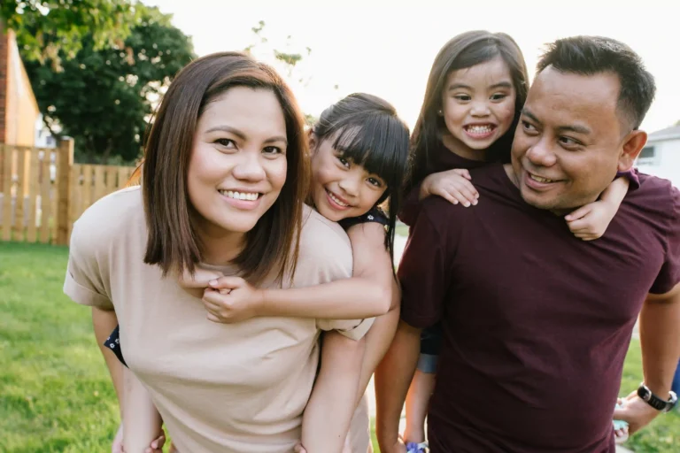 Family of four, with two young girls, in backyard