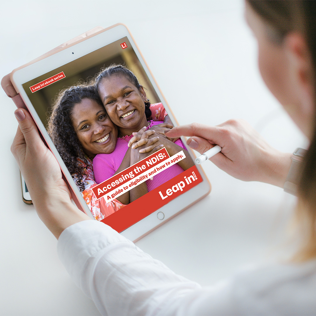 Woman holding an iPad with the Accessing the NDIS ebook showing on the screen