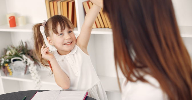 Child raising a hand to answer a question