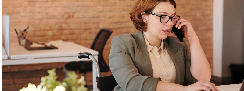 Woman with glasses talk on phone in a work environment