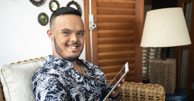portrait of a young person with a disability using tablet at home