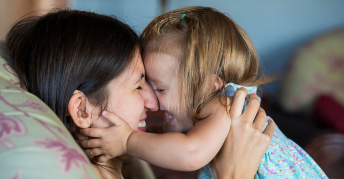 Women and child embracing on a couch.