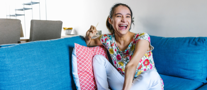 Woman with cerebral palsy sitting on a blue lounge at home