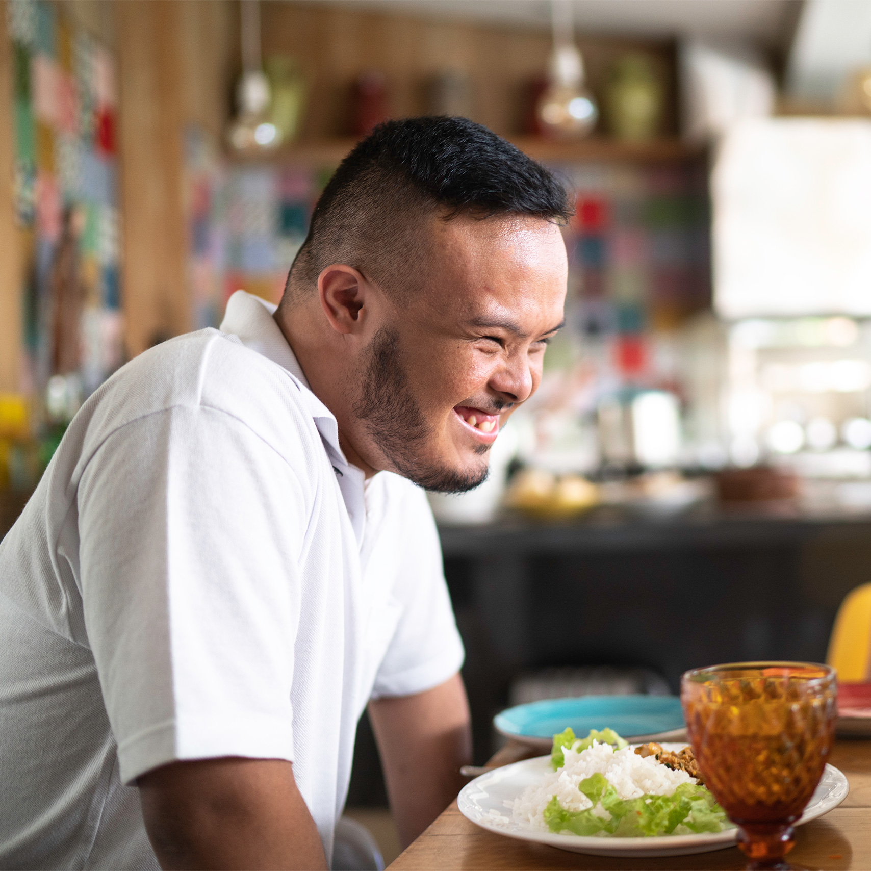 Man with dark features grins happily