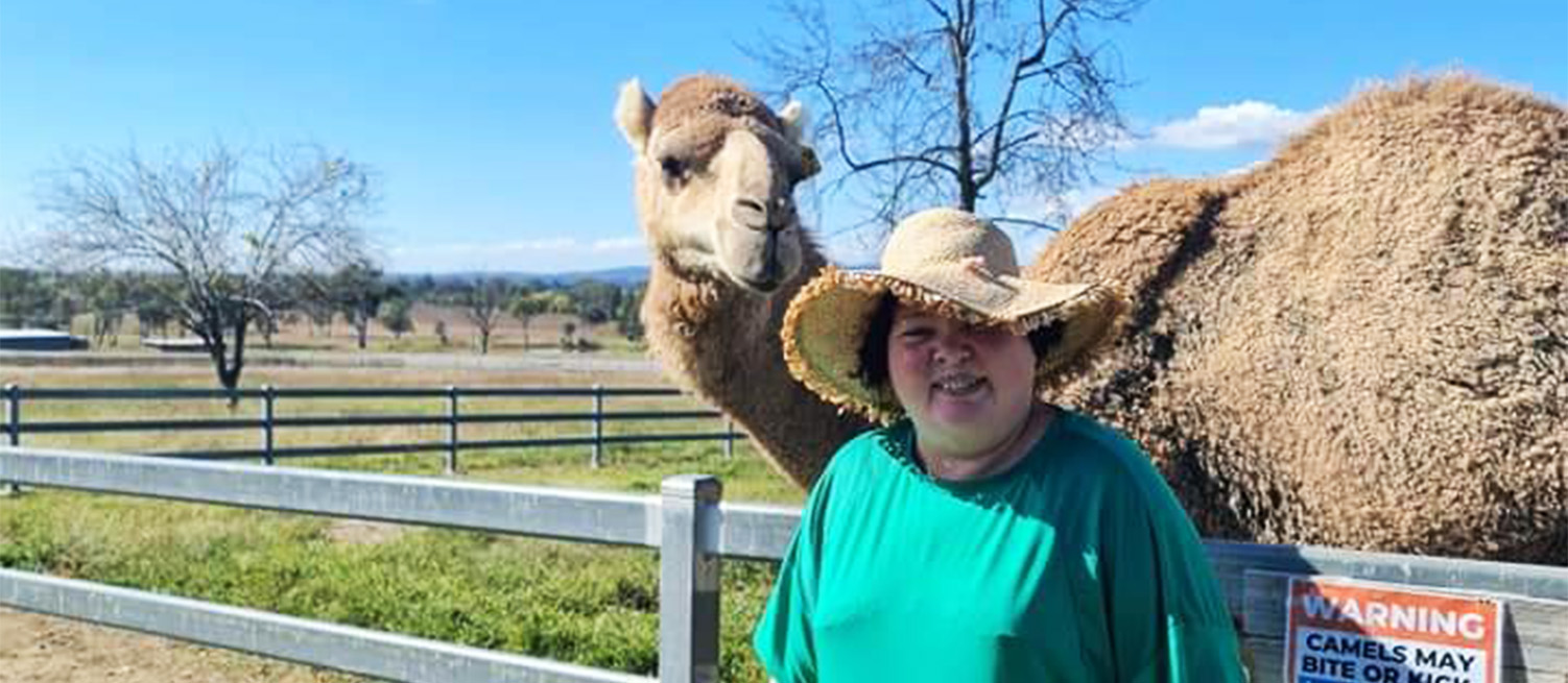 Leap in! member Lisa standing in front of a camel in it