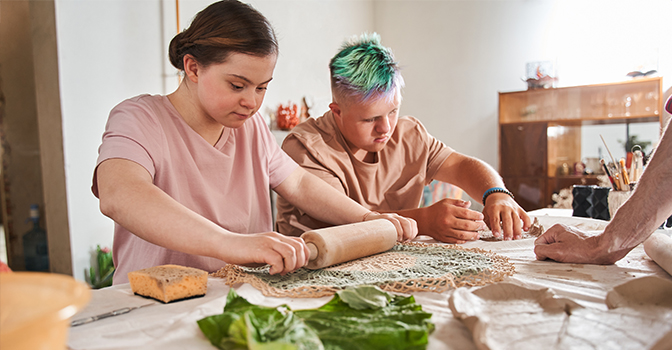 A young girl and young man making pottery