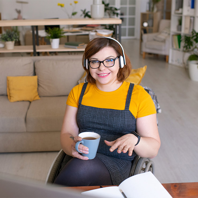 Young lady in a wheelchair in her loungeroom holding a coffee