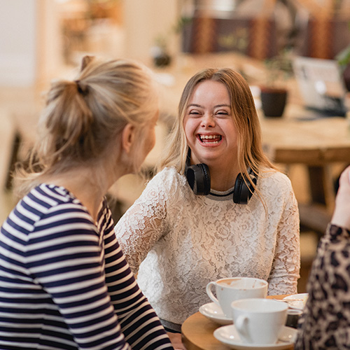 Young woman at a coffee shop with three friends