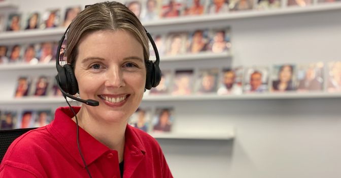 Female Leap in! team member smiling and wearing a telephone headset