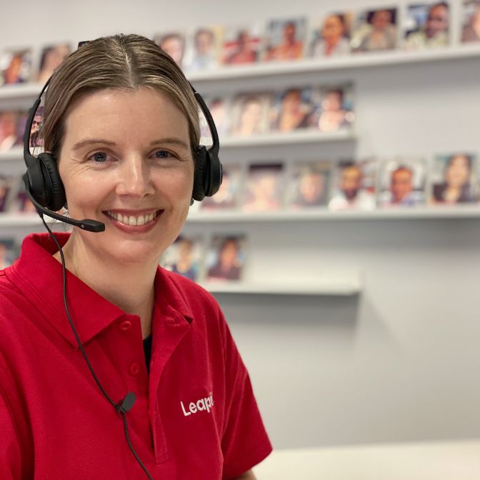 Female Leap in! team member smiling and wearing a telephone headset