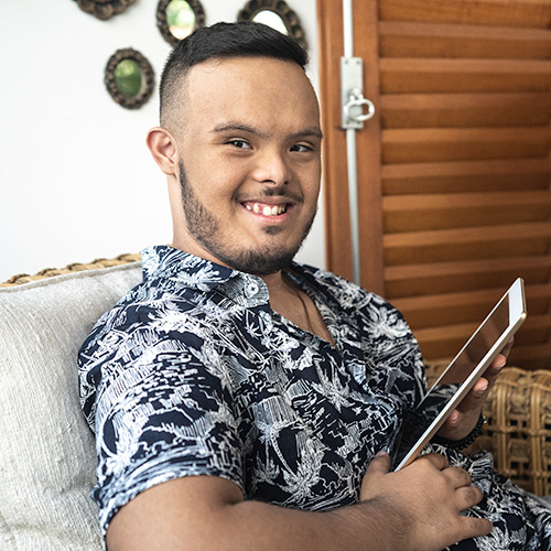 Young man sitting on the lounge smiling at the camera