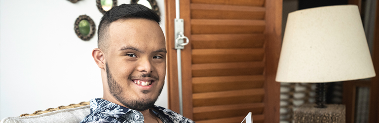 Young man sitting on the lounge smiling at the camera