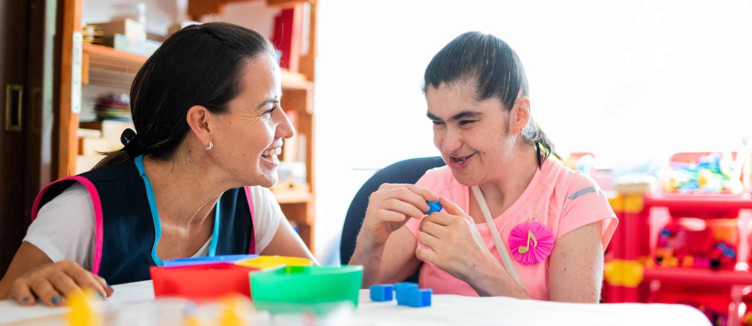 Support worker and young woman smiling.