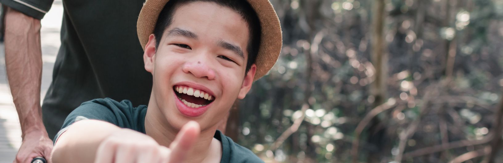 Teenage boy wearing a hat pointing at the camera