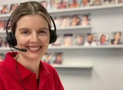 Female Leap in! team member smiling and wearing a telephone headset